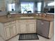 Granite counters highlight this kitchen sink with stainless steel dishwasher and white cabinets at 4875 Hansard Ave, North Port, FL 34286