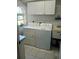 Well-lit laundry room with washer, dryer, and built-in utility sink and counter at 4875 Hansard Ave, North Port, FL 34286