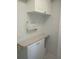 The bright laundry room features grid wallpaper, white cabinets and a folding counter at 4875 Hansard Ave, North Port, FL 34286