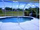 Screened-in pool offers privacy and a relaxing outdoor space with lovely lawn and garden views at 4875 Hansard Ave, North Port, FL 34286