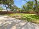 Expansive grassy backyard enclosed by a wooden fence, with a patio at 5225 20Th N St, St Petersburg, FL 33714
