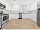 Modern kitchen with white cabinets, stainless steel appliances, granite countertops, and tiled floors at 5225 20Th N St, St Petersburg, FL 33714