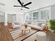 Bright living room featuring hardwood floors, modern furniture, large windows, and a contemporary ceiling fan at 5225 20Th N St, St Petersburg, FL 33714