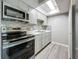 Modern kitchen features stainless steel appliances, gray cabinets, marble backsplash, and a skylight at 6100 12Th S St # 313, St Petersburg, FL 33705