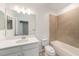 Clean bathroom features white cabinetry, a large mirror, and a tiled shower-tub combination at 6703 Citrus Creek Ln, Tampa, FL 33625