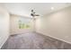 Neutral bedroom with carpeted floors, two windows, and ceiling fan at 6703 Citrus Creek Ln, Tampa, FL 33625