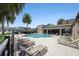 Community pool with lounge chairs and a covered outdoor kitchen area on a sunny day at 6703 Citrus Creek Ln, Tampa, FL 33625