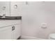 Close-up of a powder room featuring a granite countertop, white cabinetry, and modern fixtures at 7308 Hermes Ct, Apollo Beach, FL 33572