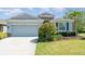 Charming single-story home with a well-manicured lawn, two-car garage, and appealing landscaping at 7308 Hermes Ct, Apollo Beach, FL 33572