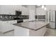 Modern kitchen featuring white cabinets, granite countertops, stainless steel appliances, and a stylish backsplash at 7308 Hermes Ct, Apollo Beach, FL 33572