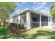 Screened-in patio with brick flooring, ceiling fans, and manicured lawn for outdoor enjoyment at 7308 Hermes Ct, Apollo Beach, FL 33572