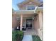 Charming front porch with seating, decorative plants, and a stylish entryway with a stone accent wall at 1212 Georgia Trace Ave, Valrico, FL 33596