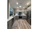 Stylish kitchen boasts gray cabinetry, stainless steel appliances, quartz countertops, and modern lighting fixtures at 1212 Georgia Trace Ave, Valrico, FL 33596