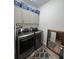 Functional laundry room with modern washer and dryer, overhead cabinets, and stylish decor at 1212 Georgia Trace Ave, Valrico, FL 33596