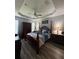 Serene main bedroom featuring a tray ceiling, a four-poster bed, and coordinated furniture at 1212 Georgia Trace Ave, Valrico, FL 33596
