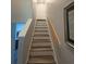 A bright staircase featuring wood treads and handrails leads to the upper level of this home at 1212 Georgia Trace Ave, Valrico, FL 33596