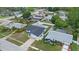 Aerial view of a single-story home with two-car garage, pool, manicured lawn, and mature trees at 14506 Sutter Pl, Tampa, FL 33625