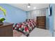 Bedroom with a bed with red, white, and blue patterned bedding and dark-wood dresser at 14506 Sutter Pl, Tampa, FL 33625