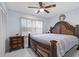 A traditional bedroom featuring an ornate wood frame bed, ceiling fan, and natural light from a window at 14506 Sutter Pl, Tampa, FL 33625