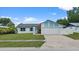 Inviting single-story residence features a spacious driveway and attached garage, complemented by verdant lawn at 14506 Sutter Pl, Tampa, FL 33625