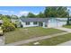 Single-story home with blue accents, two-car garage, and a lush green lawn at 14506 Sutter Pl, Tampa, FL 33625