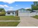 Charming single-story home featuring a two-car garage, well-maintained lawn, and light blue accents at 14506 Sutter Pl, Tampa, FL 33625