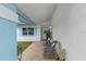 Inviting covered front porch with stone flooring and seating area with charming rocking chairs and plants at 14506 Sutter Pl, Tampa, FL 33625