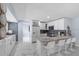 A modern, bright kitchen with a breakfast bar, white cabinets, stainless steel appliances, and marble floors at 14506 Sutter Pl, Tampa, FL 33625