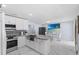 A modern eat-in kitchen featuring an island, sleek appliances, marble flooring, and stylish white cabinets at 14506 Sutter Pl, Tampa, FL 33625