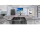 A bright kitchen with marble countertops, stainless steel sink, white cabinetry, and stainless steel appliances at 14506 Sutter Pl, Tampa, FL 33625