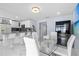 A sunlit eat-in kitchen with white barstools, white cabinetry, stainless steel appliances, and stylish pendant lighting at 14506 Sutter Pl, Tampa, FL 33625