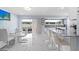 Bright kitchen and dining area featuring modern white cabinets, countertops, and stainless steel appliances overlooking the pool at 14506 Sutter Pl, Tampa, FL 33625