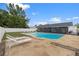 Spacious backyard featuring a sparkling pool, stone patio, lounge chairs, and well-maintained fencing for privacy at 14506 Sutter Pl, Tampa, FL 33625