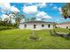 View of the backyard with a large grassy area, patio, and landscaping at 2706 Flagami Ln, North Port, FL 34286