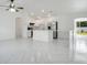 Modern open-concept kitchen with stainless steel appliances, white cabinets, and island with bar seating at 2706 Flagami Ln, North Port, FL 34286