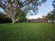 Backyard view featuring a large, manicured lawn and the back of the house with a patio at 663 68Th S Ave, St Petersburg, FL 33705