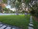 Large grassy backyard with mature trees and a stone paver path at 663 68Th S Ave, St Petersburg, FL 33705