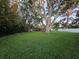 Spacious backyard with mature trees, manicured lawn, and partially visible patio set at 663 68Th S Ave, St Petersburg, FL 33705