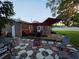 Backyard patio with a fire pit, patio furniture and a wooden deck with red patio umbrellas at 663 68Th S Ave, St Petersburg, FL 33705