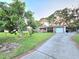 A charming home featuring a well-maintained lawn, mature trees, and a long driveway at 663 68Th S Ave, St Petersburg, FL 33705