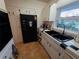 Kitchen with tile floors, black refrigerator, and double basin sink under a window at 663 68Th S Ave, St Petersburg, FL 33705