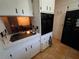View of the kitchen featuring white cabinets, black appliances, and access to dining area at 663 68Th S Ave, St Petersburg, FL 33705