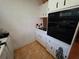 Kitchen featuring white cabinets, built-in black oven, and tile flooring at 663 68Th S Ave, St Petersburg, FL 33705