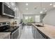 Modern kitchen featuring stainless steel appliances and granite countertops open to living area at 8126 Muddy Pines Pl, Tampa, FL 33635