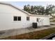 View of the home's exterior featuring an AC unit and back door at 7342 Skyview Ave, New Port Richey, FL 34653