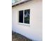 Exterior shot showcasing a white-framed window set against a textured white wall at 7342 Skyview Ave, New Port Richey, FL 34653