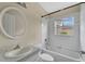 This bright bathroom features a tub and shower combo, round mirror, and sink at 22802 Roderick Dr, Land O Lakes, FL 34639