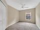 This carpeted bedroom includes a ceiling fan, a closet, and a large window at 22802 Roderick Dr, Land O Lakes, FL 34639