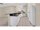 Kitchen area featuring white appliances, plenty of cabinet space, and a breakfast bar overlooking the living room at 22802 Roderick Dr, Land O Lakes, FL 34639