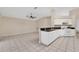 Kitchen open to the living room, featuring white cabinetry, appliances, and a breakfast bar at 22802 Roderick Dr, Land O Lakes, FL 34639